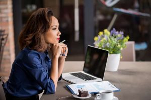 Business woman at desk staring off into the distance wondering the difference between Exclusive vs. Shared Leads