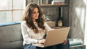Woman on laptop reading The Ultimate Guide to Buying Life Insurance Leads