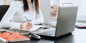 Life Insurance Agent looking at Computer Taking Notes on how to Get More Referrals as a Life Insurance Agent