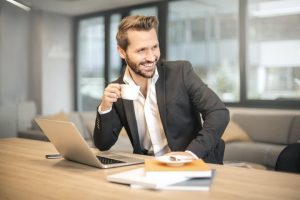 Business man smiling at desk thinking about How Life Insurance Agents Can Get FREE Leads