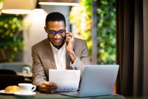 Life Insurance Agent Sitting at Desk on Phone in front of Laptop Calling Final Expense Leads