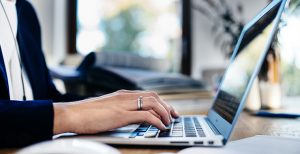 Business Woman Typing on computer Finding the Best CRM for Life Insurance Agents